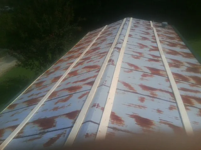 Rusted metal roof panels with new wood purlins before replacement — Storm Damage Roof Repair in Assonet by Roofing Brothers