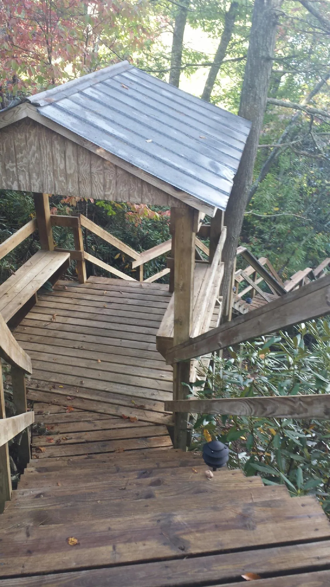 Metal roofed shelter over wooden steps on a wooded walkway — Skylight Repair & Installation work by our crew in Assonet