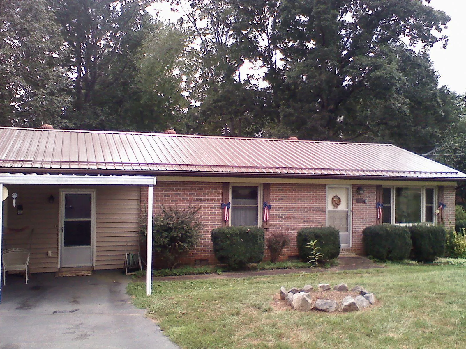 Bronze metal roof and carport on a brick ranch home — Roof Repair work by our crew in Assonet